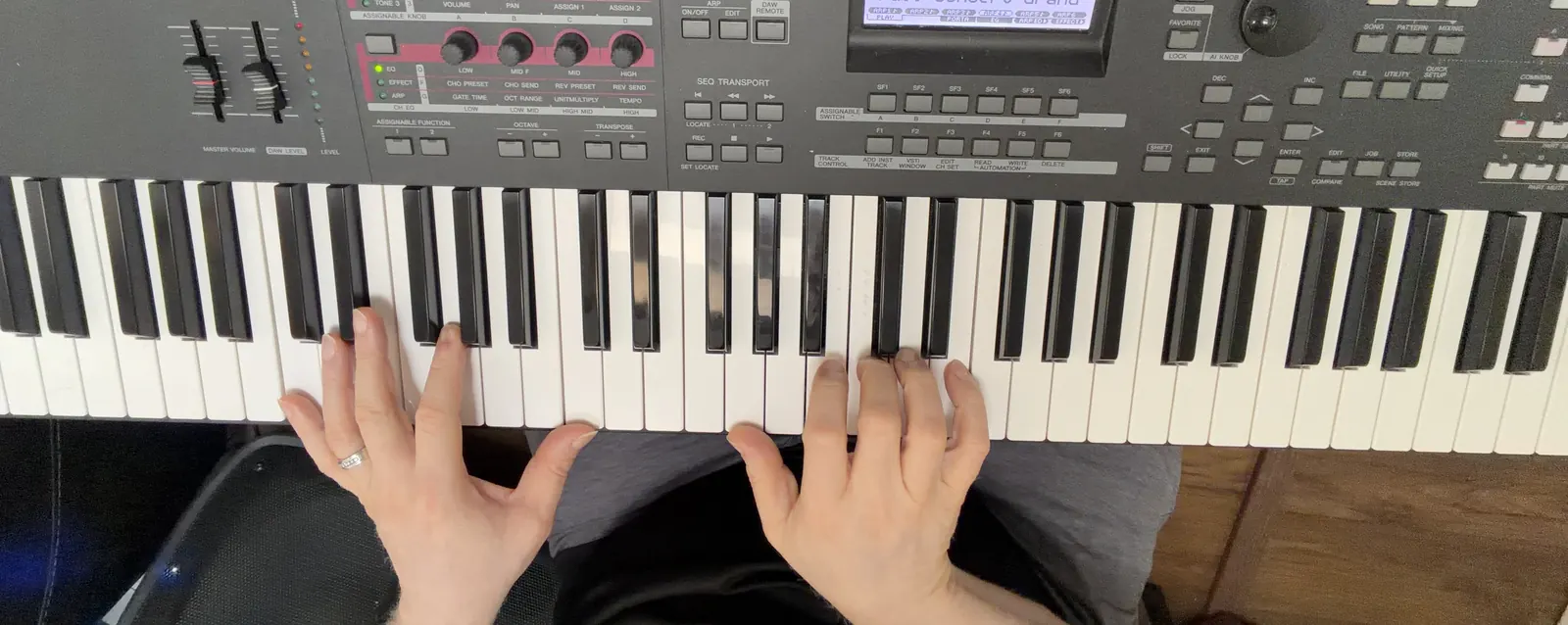 Henry's hands on his keyboard, playing a chord, seen from where he sits.